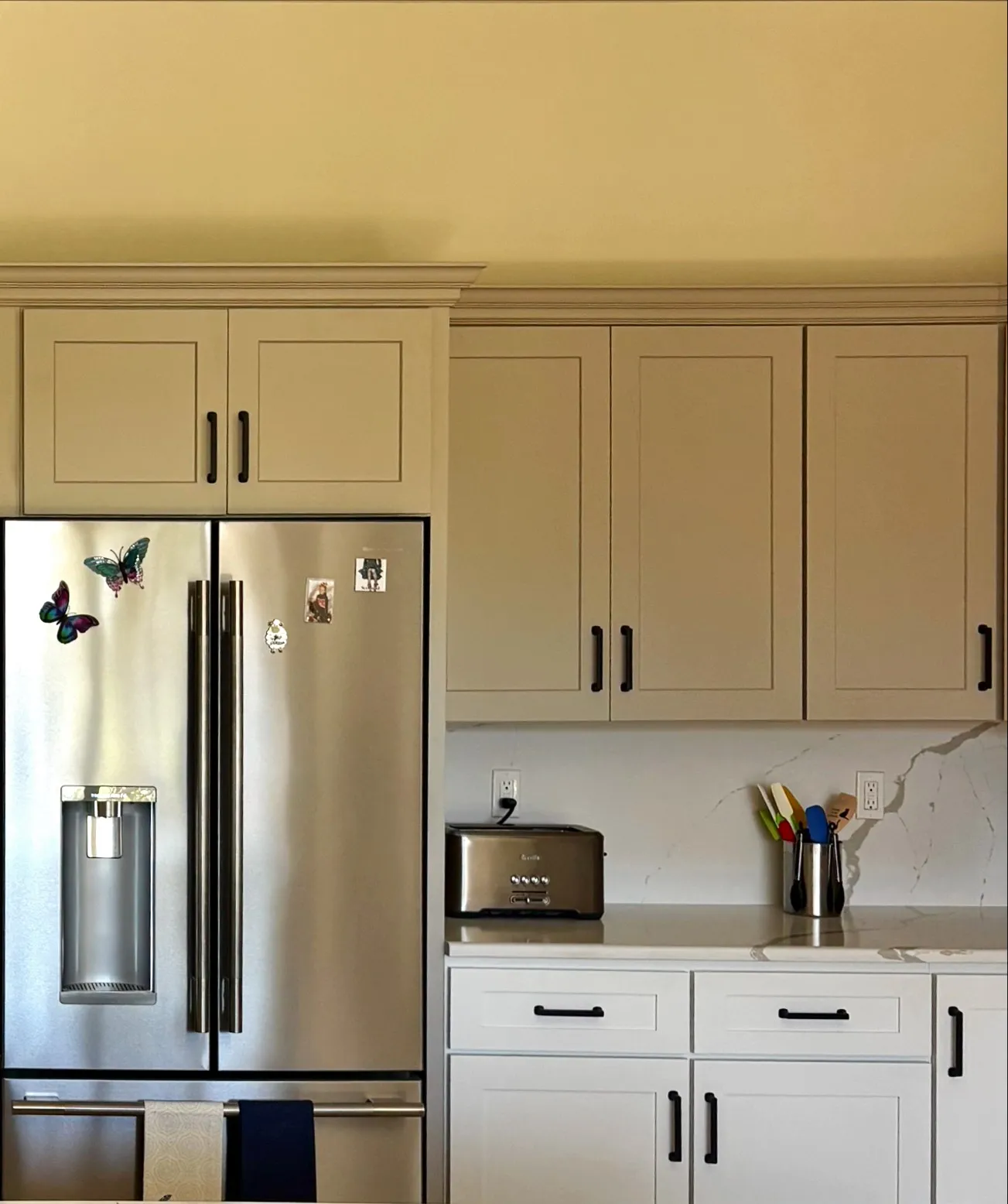White shaker kitchen cabinets and quartz countertop next to stainless refrigerator in Belleview, FL